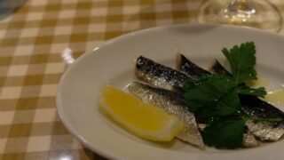 鰯のマリネの前菜皿。レモンとイタリアンパセリ、ギンガムチェックのクロス