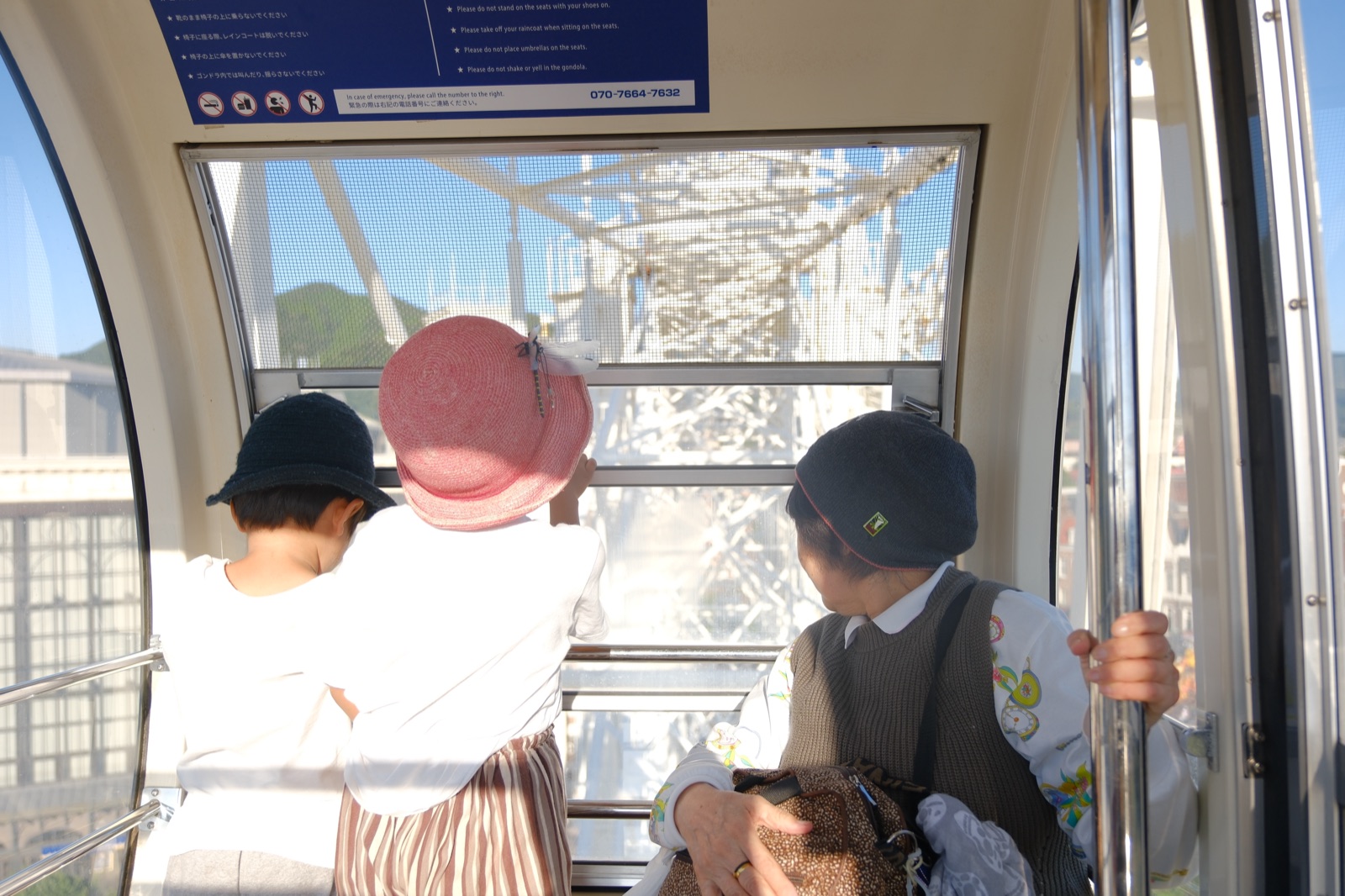 観覧車の中から外を見るふたりの後ろ姿