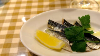 鰯のマリネの前菜皿。レモンとイタリアンパセリ、ギンガムチェックのクロス