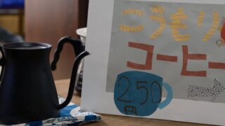 こうもりコーヒーの手作りの看板と、黒いコーヒーポット。一杯250円