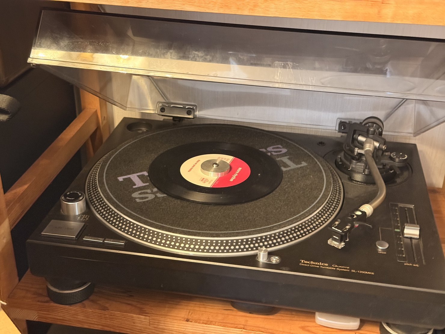 Technics SL-1200MK6に白いレコードが載って回っているところ。青いストロボの光とトーンアーム