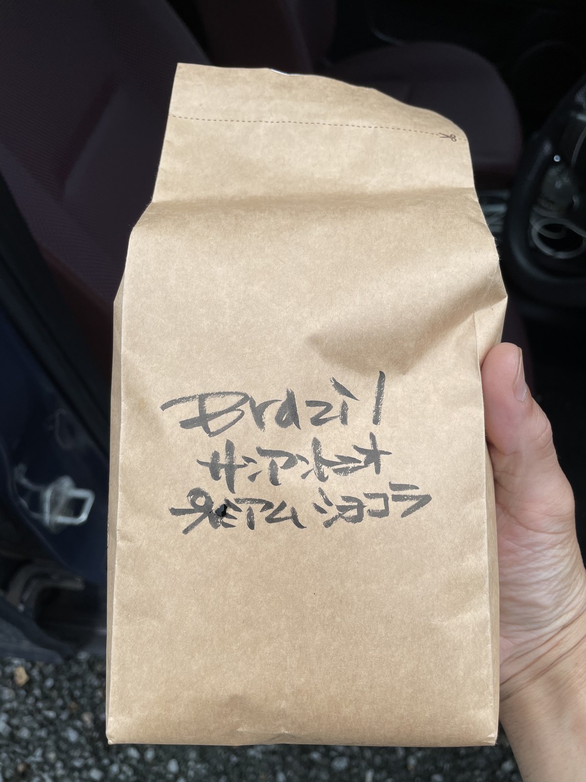 「Brazil サンアントニオ プレミアムショコラ」と手書きされた、クラフト紙のコーヒー豆の袋