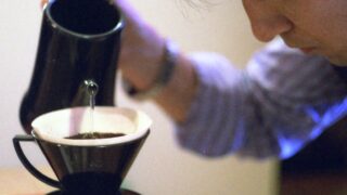 真剣な横顔でポットからコーヒーを注ぐフィルム写真