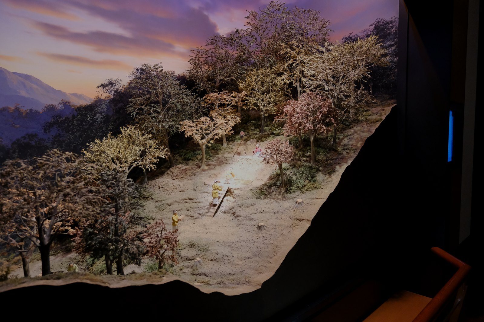 荒神谷遺跡の発掘の様子を再現したジオラマ。山の斜面を削った段に、人がしゃがんで掘っている(スポットライトの部分が見えるよう、少し暗くした)